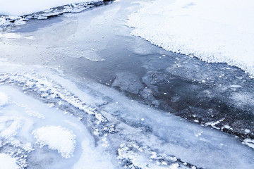 Frozen Katun river channel with ice and snow in the Altai mountains in winter.