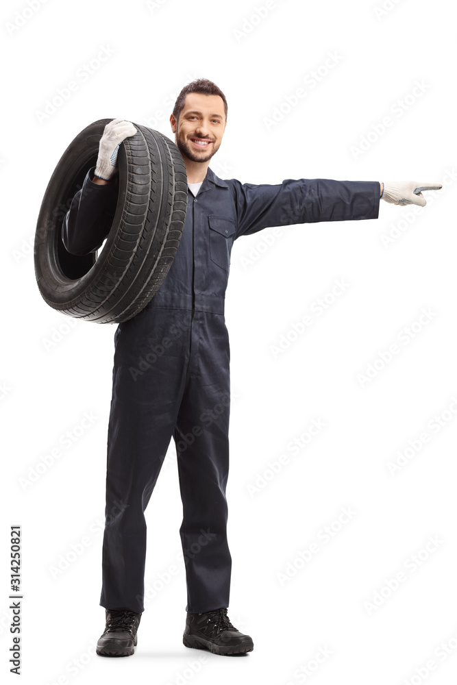 Poster Auto mechanic in a uniform carrying a car tire and pointing to the side