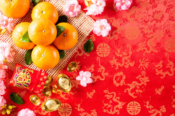 Chinese new year festival decorations pow or red packet, orange and gold ingots or golden lump on a red background. Chinese characters FU in the article refer to fortune good luck, wealth, money flow.
