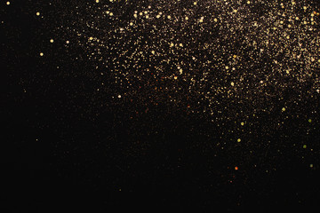 Fototapeta na wymiar Christmas Gold glitter on black background. Holiday abstract texture