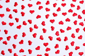 Valentine's day decorative pattern red hearts confetti on white background.