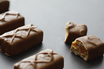 Chocolate bars on a black background in backlight. Chocolate with filling. Sweet sweets for snack and tea.