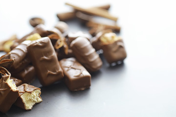 Chocolate bars on a black background in backlight. Chocolate with filling. Sweet sweets for snack and tea.