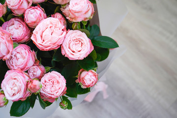 Pink peony roses, on a gray wooden background with place for text, flat lay, closeup.
