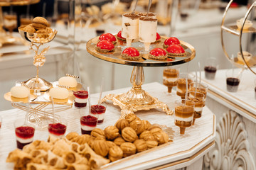 Luxury life. Bithday cakes and accesories. Party and celebration. Colorful cakes. Dessert table for a party. Delicious wedding reception candy bar dessert table full with cakes and sweets.