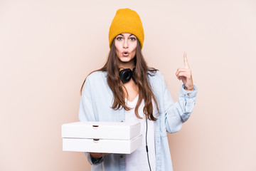 Young caucasian woman holding pizzas isolated having some great idea, concept of creativity.