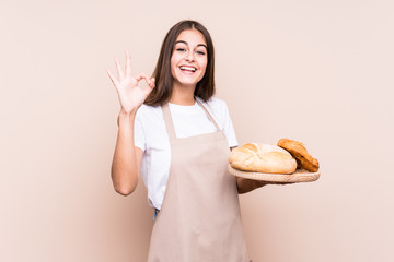 Young caucasian baker woman isolated cheerful and confident showing ok gesture. - obrazy, fototapety, plakaty