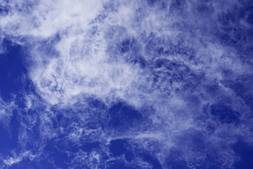 Blue high sky with light feathery clouds. Circle type of clouds.