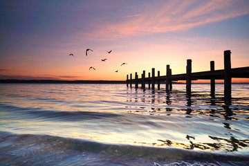 Naklejka premium Wellen am Holzsteg