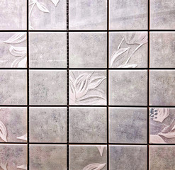 Gray ceramic tiles with floral pattern for wall and floor decoration. Concrete stone surface background. Aged vintage texture for interior design project.