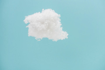 white fluffy cloud made of cotton wool isolated on blue background
