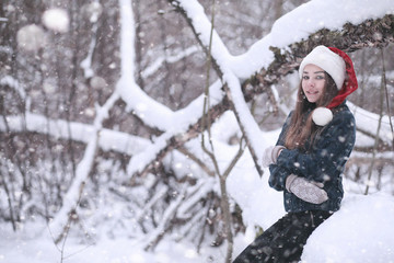 Girl in a winter park in snowfall