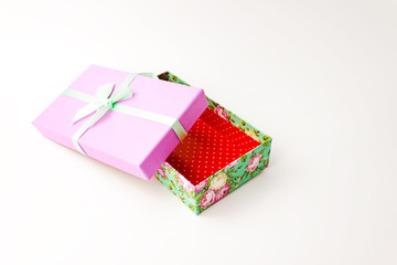 Single flowered gift purple lid paper box and bow on white background. Holyday present concept.