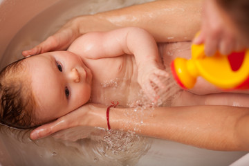 Fototapeta premium cute newborn baby bathes in the bathroom. The concept of a toddlers ' swimming