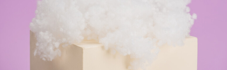 white fluffy cloud made of cotton wool on cube isolated on violet background