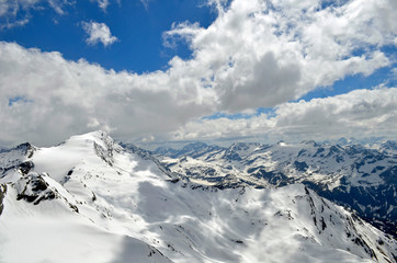 Fototapeta na wymiar Austria europe mountain tops with snow on it and clouds and blue sky