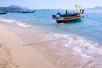 Longtail boat in the clear sea over blue sky.
