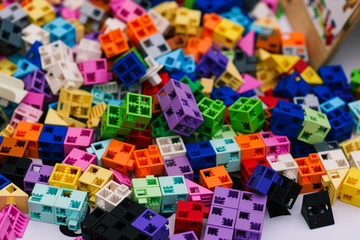 Details of the children's designer. Scattered colored plastic blocks of the designer on the table. Children's designer for the development of motor skills, thinking and imagination