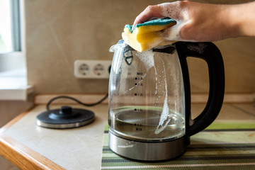 Woman's hand cleaning the electric kettle. Housework and housework.