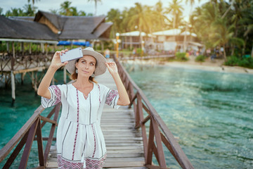 Vacation and technology. Outdoor portrait of pretty young woman taking selfie with her  smartphone on tropical beach.