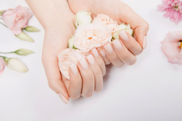 Concept bio nature cosmetics skin care. Beautiful stylish trendy female pink manicure with flower on background, top view