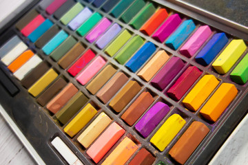 Used colorful pastel chalks in geometrical order. Artist supplies and accessories. Abstract horizontal background. Rainbow colors.