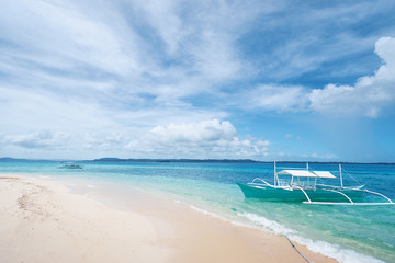 Beautiful landscape with tropical white sand beach with fishing boats. Siargao Island, Philippines.