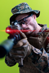 Fototapeta premium soldier in action aiming laseer sight optics green background