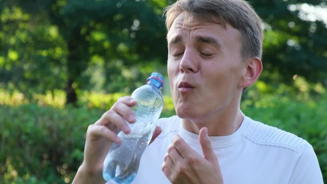 Man drinking cold water and suffers pain. Man spits water back. Hypersensitivity of teeth.