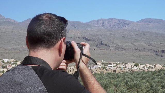 Caucasian Male Tourist Taking Photos of Abandoned Old Ruined Village of Al Hamra near Nizwa, Oman