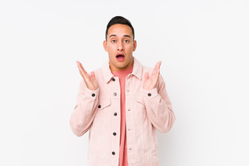 Young latin man posing isolated surprised and shocked.