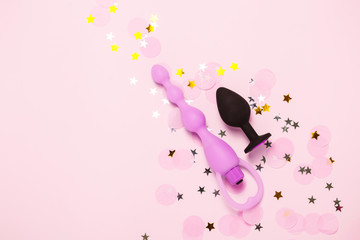 Adult sex toys and accessories and strawberries on pink background. Anal dildo, butt plug. Top...