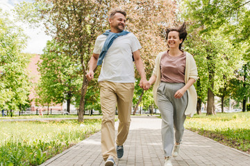 Obraz premium Middle-aged married couple running in the park.