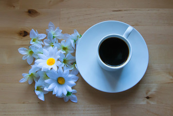 Primer plano de taza de café con margaritas blancas