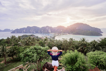 Fototapeta na wymiar Traveling by Thailand. Young woman enjoying wonderful sunset on Phi Phi Don island view. point.