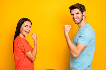 Profile photo of funny two people guy lady celebrating competition winning sportive champions wear casual blue orange t-shirts jeans isolated yellow color background