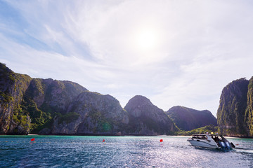 Fototapeta na wymiar Travel by Thailand. Beautiful tropical lanscape with yacht sailing the sea with famous Maya Bay on the background.