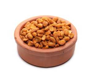 Spicy peanuts pile in clay bowl isolated on white background