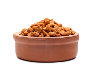 Spicy peanuts pile in clay bowl isolated on white background