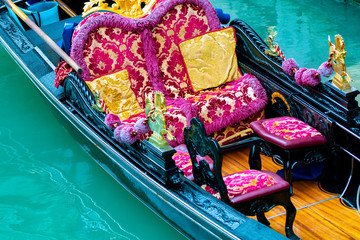 Venice, Italy. Inside a fancy decor/ decorated Venetian gondola. Famous romantic tour boat ride embellished for tourists. Italian culture transportation on lagoon water canal channel in the city.