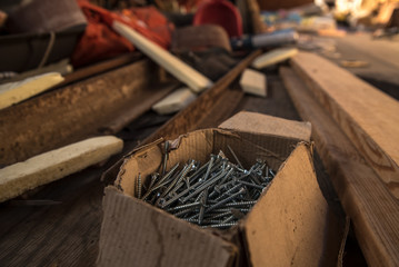 A cardboard box with screws lies on the floor at the construction of the house