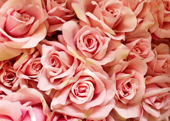 Background of bright artificial pink roses flowers. Close up.