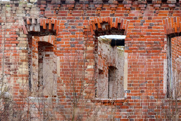 Fragment of a destroyed brick wall with empty windows
