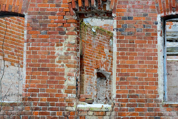 Fragment of a destroyed brick wall with empty windows