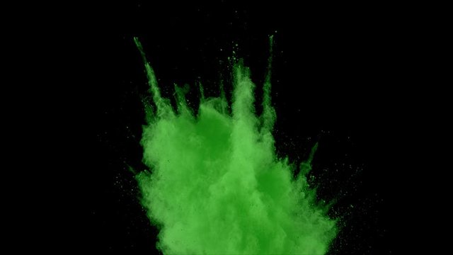 Realistic green powder dust explosion on black background. Slow motion movement of dust remains