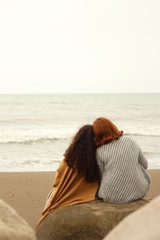 two women sitting in beach together
