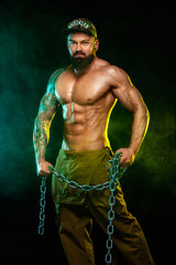 Gay streptizer with naked torso. Muscular fitness sports man, atlete with chains in fitness gym....