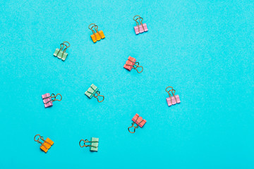 Different bright paper clip pattern on pink background. Top view, flat lay. Minimal school or office stationery.