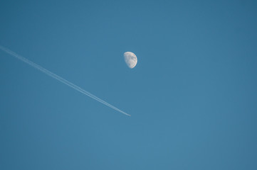 airplane and moon in blue sky