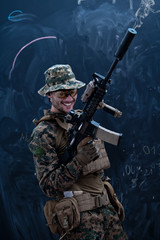 Fototapeta premium soldier firing into the air in front of black chalkboard